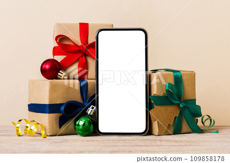 Digital phone mock up with rustic Christmas decorations for app presentation with empty space for you design. Christmas online shopping concept. Tablet with copy space on colored background Digital phone mock up with rustic Christmas decorations for app presentation with empty space for you design. Christmas online shopping concept. Tablet with copy space on colored background 109858178