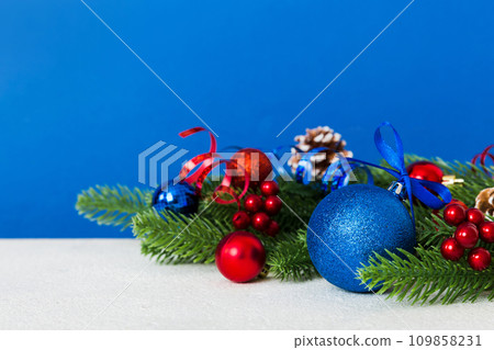 New Year Christmas tree toy, branches of a christmas tree, New Year decorations on a colored background 109858231