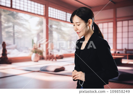 Woman burning incense at a funeral Woman burning incense at a funeral 109858249