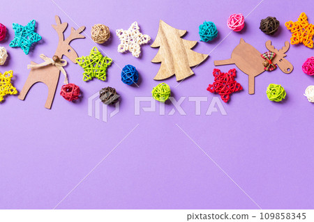 New Year decorations on purple background. Festive stars and balls. Merry Christmas concept with empty space for your design New Year decorations on purple background. Festive stars and balls. Merry Christmas concept with empty space for your design 109858345