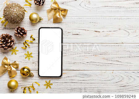 Digital phone mock up with rustic Christmas decorations for app presentation top view with empty space for you design. Christmas online shopping concept. Tablet with copy space on colored background Digital phone mock up with rustic Christmas decorations for app presentation top view with empty space for you design. Christmas online shopping concept. Tablet with copy space on colored background 109859249