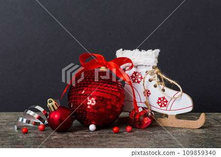Christmas ball with skates on colored background. decoration bauble with ribbon bow with copy space 109859340