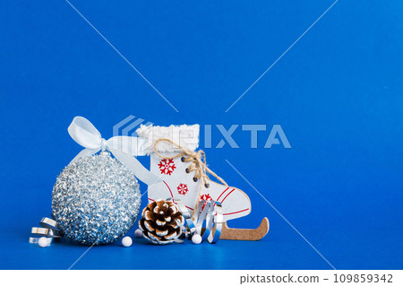 Christmas ball with skates on colored background. decoration bauble with ribbon bow with copy space Christmas ball with skates on colored background. decoration bauble with ribbon bow with copy space 109859342