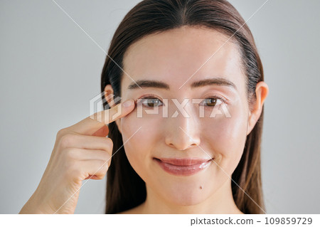 一名 30 多歲的女性將手指放在右眼上 一名 30 多歲的女性將手指放在右眼上 109859729