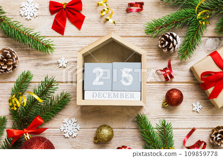 Christmas calendar 25 december. Christmas gift, fir branches, pine cones. Flat lay, top view. New Year decorations on a colored background Christmas calendar 25 december. Christmas gift, fir branches, pine cones. Flat lay, top view. New Year decorations on a colored background 109859778