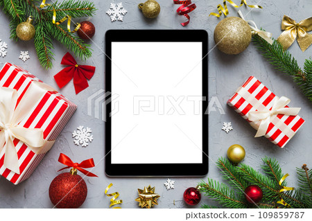 Digital tablet mock up with rustic Christmas decorations for app presentation top view with empty space for you design. Christmas online shopping concept. Tablet with copy space on colored background Digital tablet mock up with rustic Christmas decorations for app presentation top view with empty space for you design. Christmas online shopping concept. Tablet with copy space on colored background 109859787
