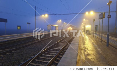 Night railway terminal. Deserted train station in fog. Concept of travelling, tourism or commuting to work Night railway terminal. Deserted train station in fog. Concept of travelling, tourism or commuting to work 109860353