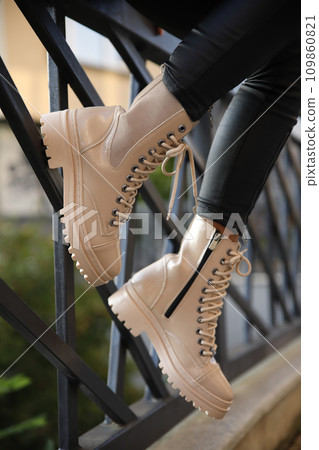 Woman in stylish leather boots and jeans outdoors. Close up of female legs in fashion footwear 109860821