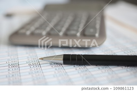 Calculator and ballpoint pen lying on document with numbers closeup Calculator and ballpoint pen lying on document with numbers closeup 109861123