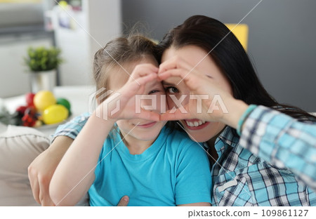 Little girl and mother hugging and showing heart together with their hands 109861127