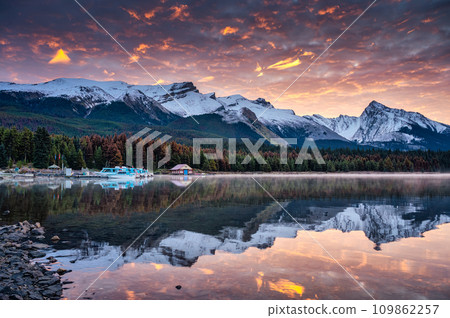 Rocky mountains with colorful sky and ferry boat on pier in Maligne Lake at Jasper national park, Canada 109862257