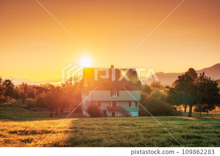 Sunrise over house on hill among the garden in countryside 109862283