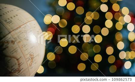 Earth rotating under Christmas tree lights background Earth rotating under Christmas tree lights background 109862573