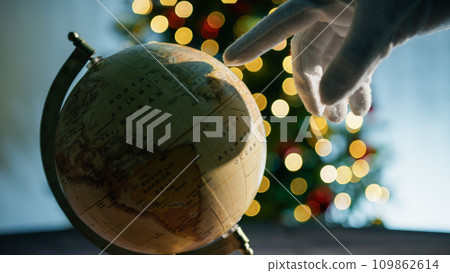 Earth rotating under Christmas tree lights background Earth rotating under Christmas tree lights background 109862614
