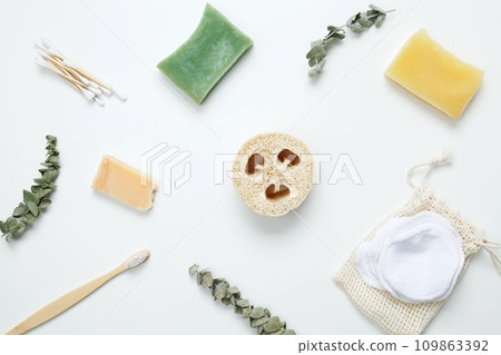 Natural organic eco cosmetics. Soap Eco, reusable cotton pads, loofah natural sponge washcloth, cotton swab, eucalyptus leaves on white background. Flat lay, top view 109863392