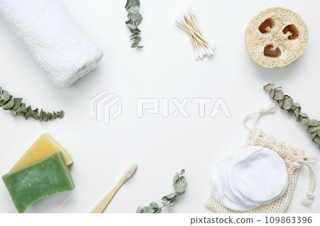 Natural organic eco cosmetics. Soap Eco, reusable cotton pads, loofah natural sponge washcloth, cotton swab, eucalyptus leaves, towel on white background. Flat lay, top view, copy space 109863396