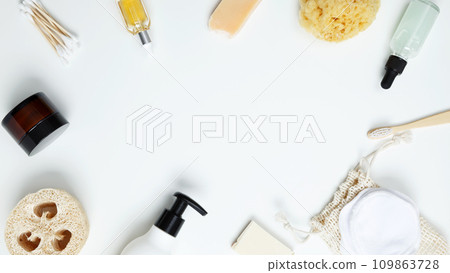 Natural organic eco cosmetics. Cosmetic containers with cream, lotion, reusable cotton pads, loofah natural sponges, cotton swab on white background. Flat lay, top view, copy space 109863728