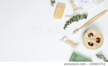 Natural organic eco cosmetics. Soap Eco, reusable cotton pads, loofah natural sponge washcloth, cotton swab, eucalyptus leaves on white background. Flat lay, top view, copy space 109863732
