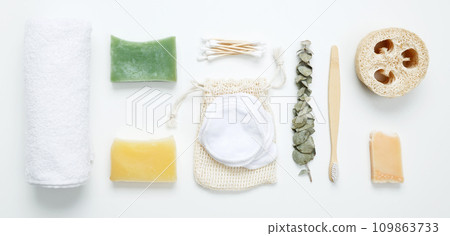 Natural organic eco cosmetics. Soap Eco, reusable cotton pads, loofah natural sponge washcloth, cotton swab, eucalyptus leaves, towel on white background. Flat lay, top view 109863733
