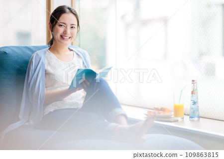 一個女人坐在沙發上和閱讀 109863815