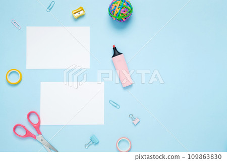 Mockup white papers and set of stationery for work and study on blue background. Back to school. Top view, flat lay, copy space Mockup white papers and set of stationery for work and study on blue background. Back to school. Top view, flat lay, copy space 109863830