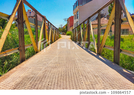 A metal pedestrian bridge connecting the two sides A metal pedestrian bridge connecting the two sides 109864557