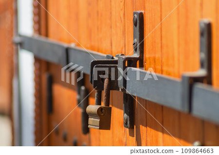 An old and reliable at the same time locking device and a barn lock of the hanging type of an ancient wooden door in the eastern country of the Asian region. Preservation acquired property in safety 109864663
