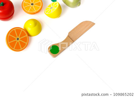 Educational toy set in the form of cut fruits and a wooden knife, isolated on white background, copy space Educational toy set in the form of cut fruits and a wooden knife, isolated on white background, copy space 109865202
