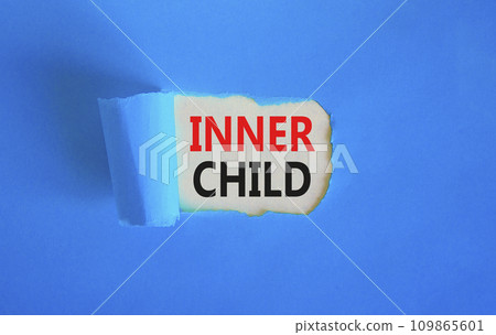 Inner child symbol. Concept words Inner child on beautiful white paper. Beautiful blue table blue background. Psychological, motivational inner child concept. Copy space. 109865601