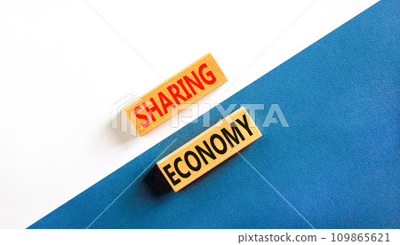 Sharing economy symbol. Concept words Sharing economy on beautiful wooden blocks. Beautiful white and blue background. Business sharing economy concept. Copy space. 109865621