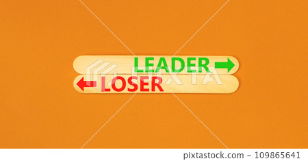 Leader or loser symbol. Concept word Leader or Loser on beautiful wooden stick. Beautiful orange table orange background. Business and leader or loser concept. Copy space. 109865641