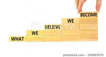 We become or believe symbol. Concept word What we believe We become on wooden block. Beautiful white table white background. Businessman hand. Business we become or believe concept. Copy space. 109865670