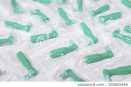 Many Green Disposable Prophy Angles with Brush, Ergonomic Shape on White Background. Dentistry, Orthodontic Product. Oral Hygiene. Horizontal Plane Many Green Disposable Prophy Angles with Brush, Ergonomic Shape on White Background. Dentistry, Orthodontic Product. Oral Hygiene. Horizontal Plane 109865846