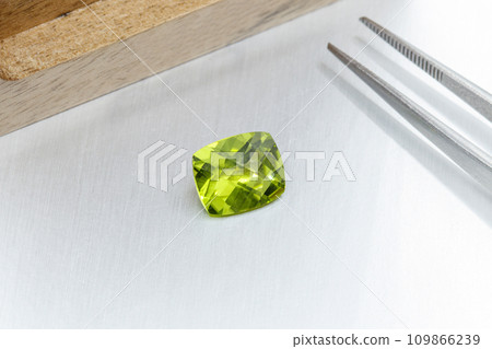 macro mineral faceted stone cut Peridot on a gray background 109866239