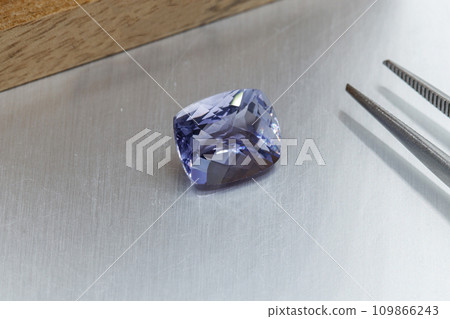 macro mineral faceted stone Cordierite on a gray background macro mineral faceted stone Cordierite on a gray background 109866243