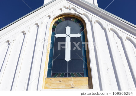Wooden White Church Stained glass window with Cross, Blue Sky On Background. Christian Religious Holiday Easter or Radonitsa. Horizontal Plane 109866294