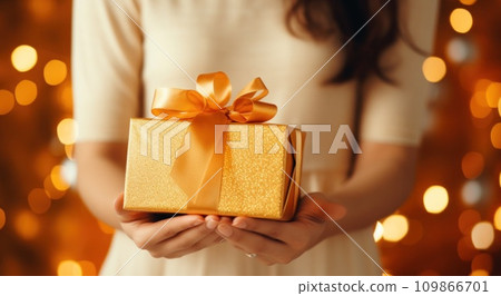 a girl is holding her golden gift box 109866701
