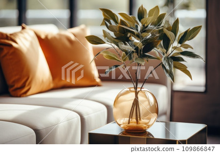 a plant is on a table beside a couch. 109866847