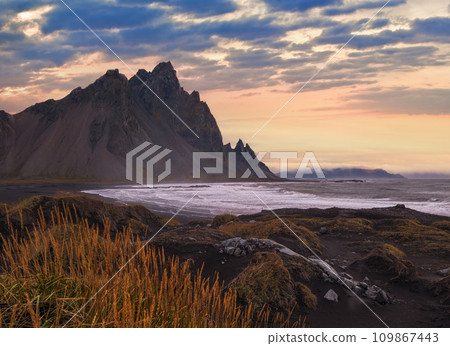 Sunrise Stokksnes cape sea beach and Vestrahorn Mountain, Iceland. Amazing nature scenery, popular travel destination. Autumn grass on black volcanic sand dunes. Sunrise Stokksnes cape sea beach and Vestrahorn Mountain, Iceland. Amazing nature scenery, popular travel destination. Autumn grass on black volcanic sand dunes. 109867443
