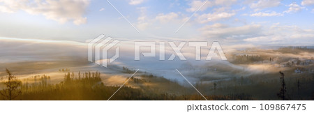 Clouds illuminated by the morning sun floating low over the valley. Country panorama view from Slowakian High Tatras. Clouds illuminated by the morning sun floating low over the valley. Country panorama view from Slowakian High Tatras. 109867475