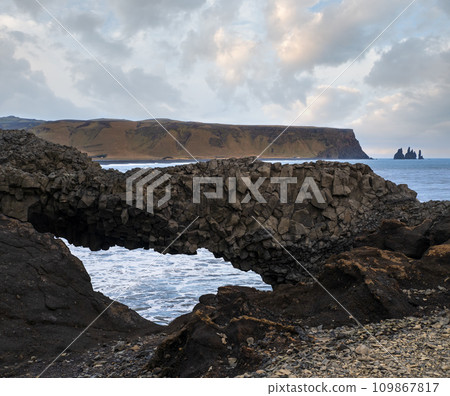 Picturesque autumn evening view to Reynisfjara ocean  black volcanic sand beach and rock formations from Dyrholaey Cape, Vik, South Iceland. Mount Reynisfjall on the background. 109867817