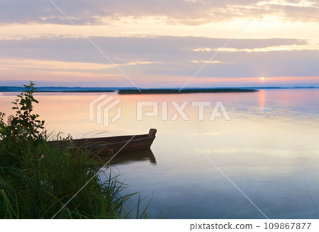 Sunset with boat near the summer lake shore 109867877