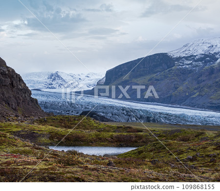 Iceland autumn tundra landscape near Haoldukvisl glacier, Iceland. Glacier tongue slides from the Vatnajokull icecap or Vatna Glacier near subglacial Esjufjoll volcano. Not far from Iceland Ring Road. Iceland autumn tundra landscape near Haoldukvisl glacier, Iceland. Glacier tongue slides from the Vatnajokull icecap or Vatna Glacier near subglacial Esjufjoll volcano. Not far from Iceland Ring Road. 109868155