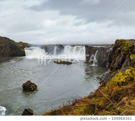 Picturesque full of water big waterfall Godafoss autumn dull day view, north Iceland. Picturesque full of water big waterfall Godafoss autumn dull day view, north Iceland. 109868161