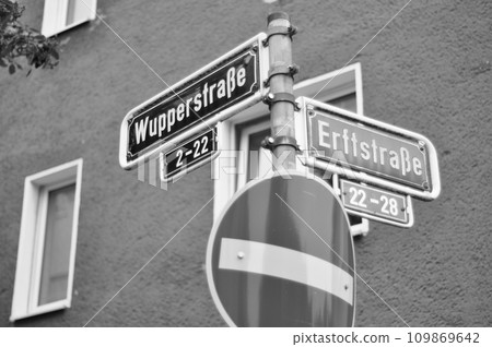 Greyscale shot of street signs indicating the intersection of Wupperstrasse and Erftstrasse streets 109869642