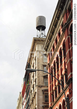 Facades of old houses in Manhattan with a water tank on the roof, New York, USA 109869643