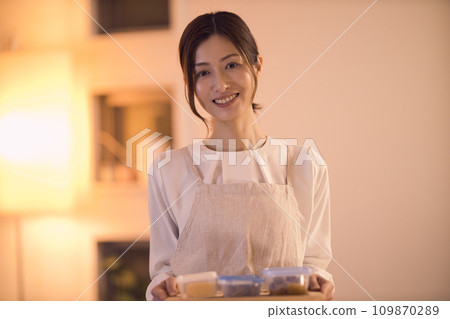 Business woman tying her hair and preparing dinner night routine Business woman tying her hair and preparing dinner night routine 109870289