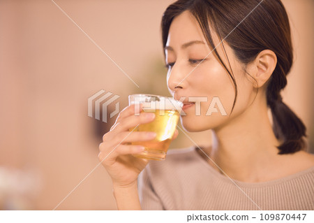 Night routine of a business woman having dinner while drinking beer 109870447