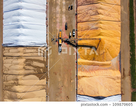 Drone view over grain storage piles being filled and covered 109870605
