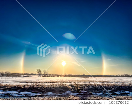 Atmospheric optical phenomenon sun dogs in the morning across a snow field. Atmospheric optical phenomenon sun dogs in the morning across a snow field. 109870612